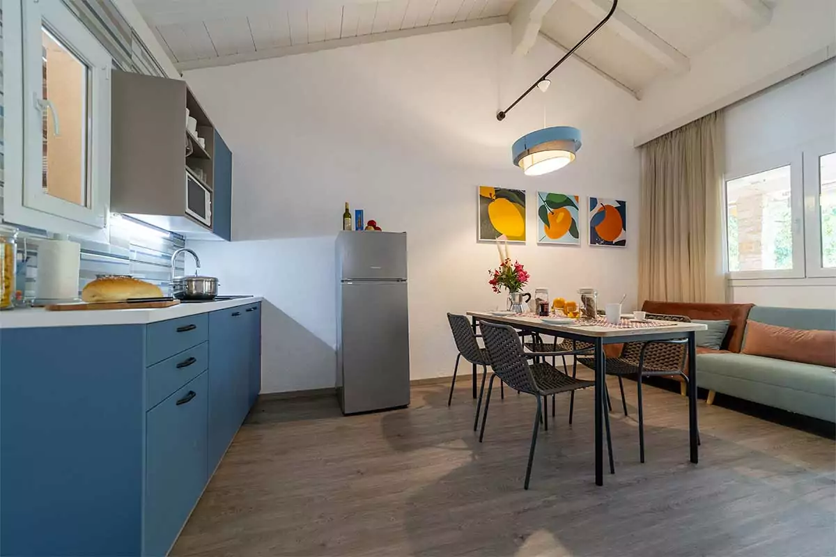 visuale della cucina con tavolo da soggiorno e salotto dell'appartamento holiday home comfort