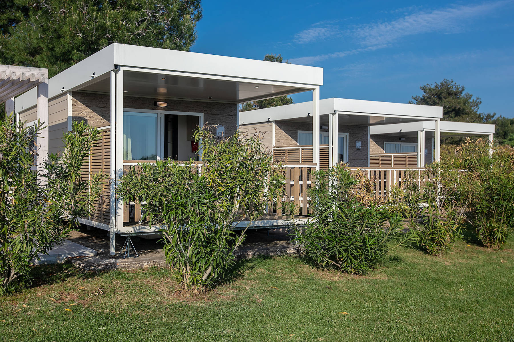 area con mobile home brioni con giardino e arbusti