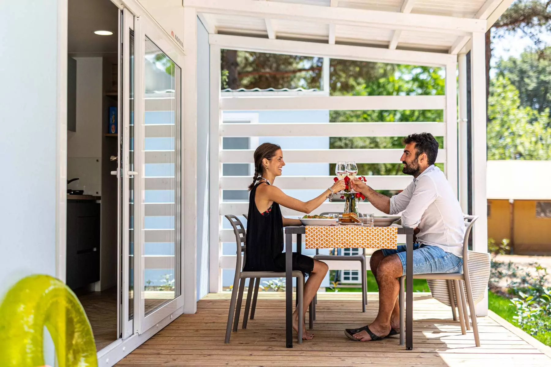 coppia che brinda al tavolo in veranda della mobilehome