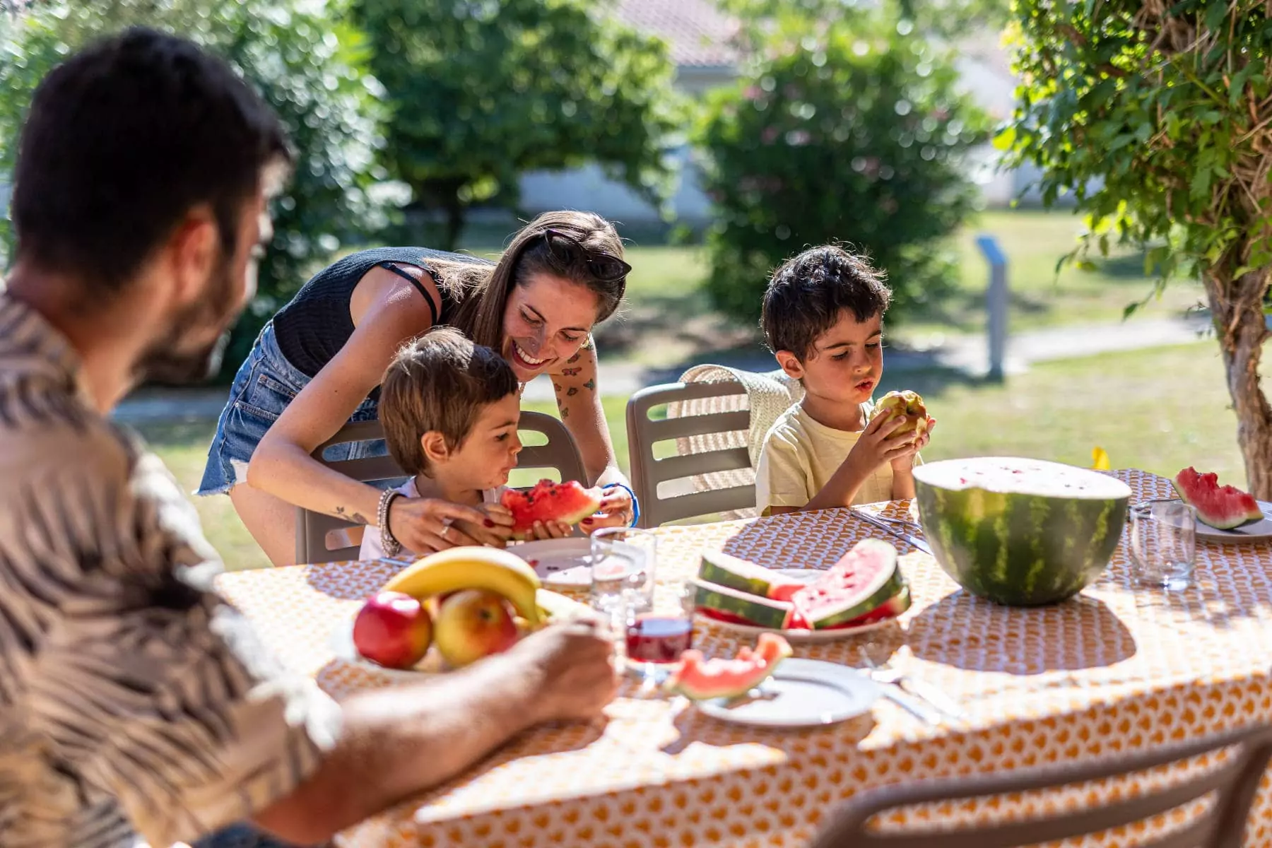 famiglia che mangia anguria al tavolo del proprio alloggio in campeggio