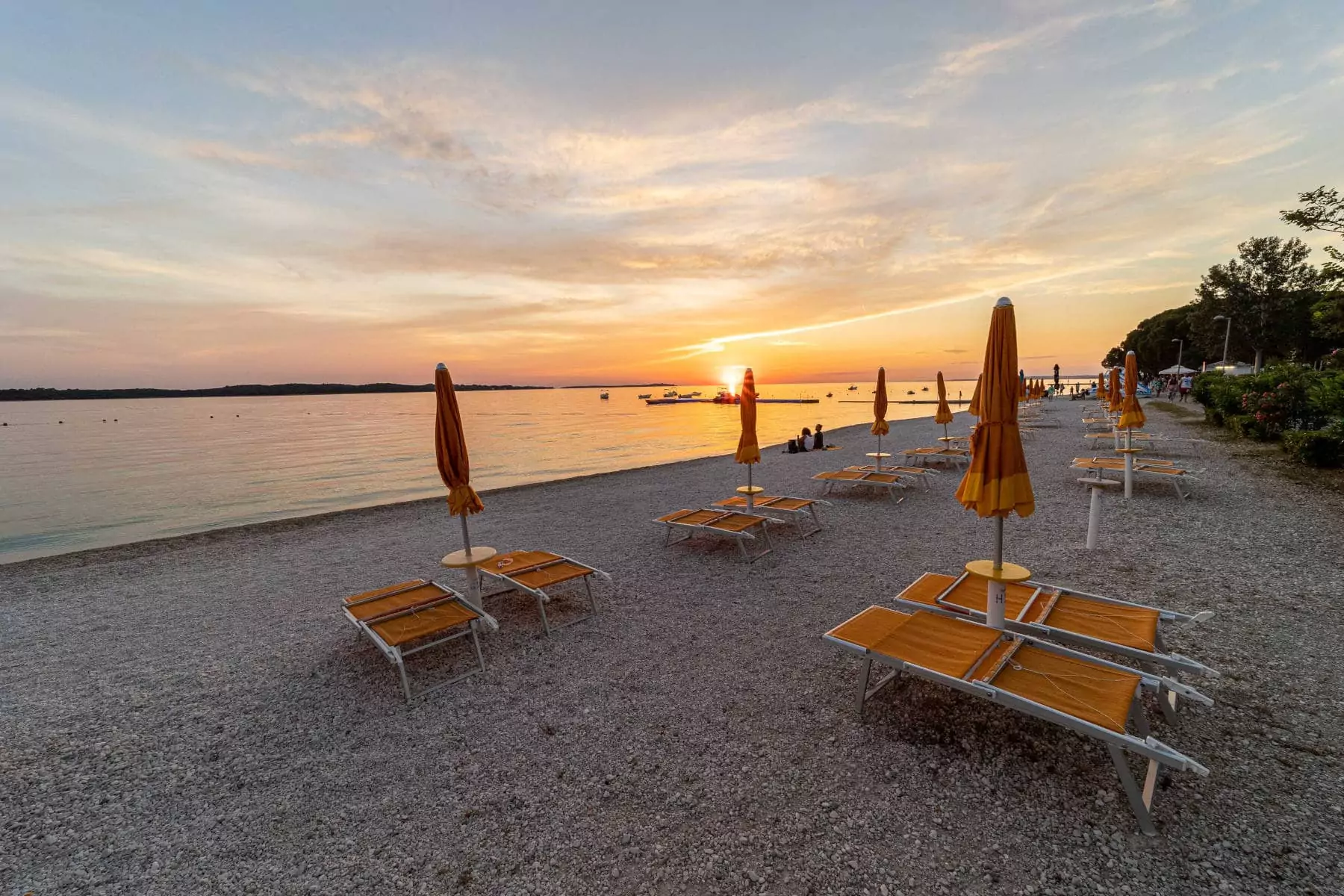 spiaggia a Fazana con ombrelloni chiusi al tramonto