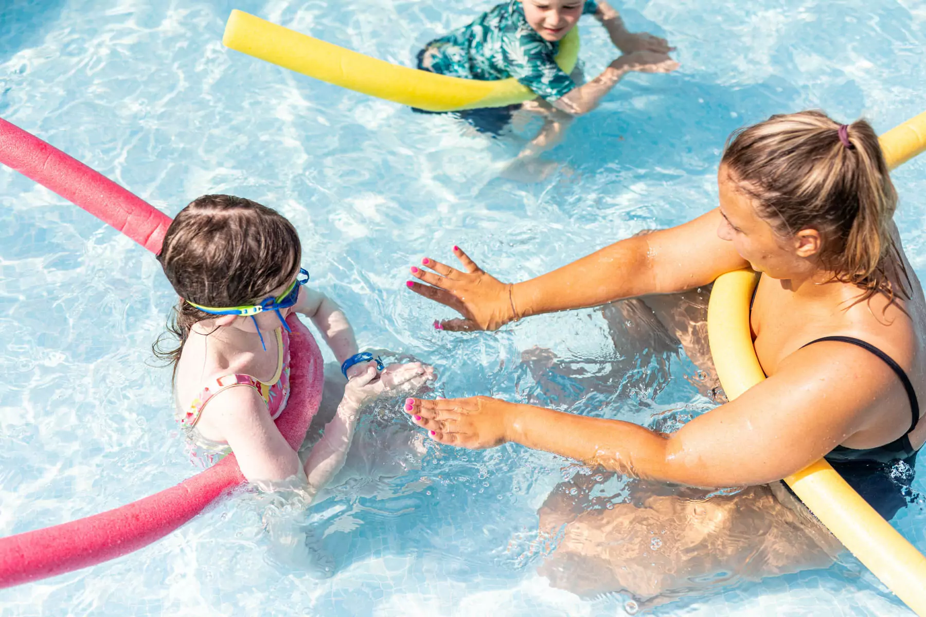 bambina e istruttrice di nuoto durante il corso nel villaggio vacanze