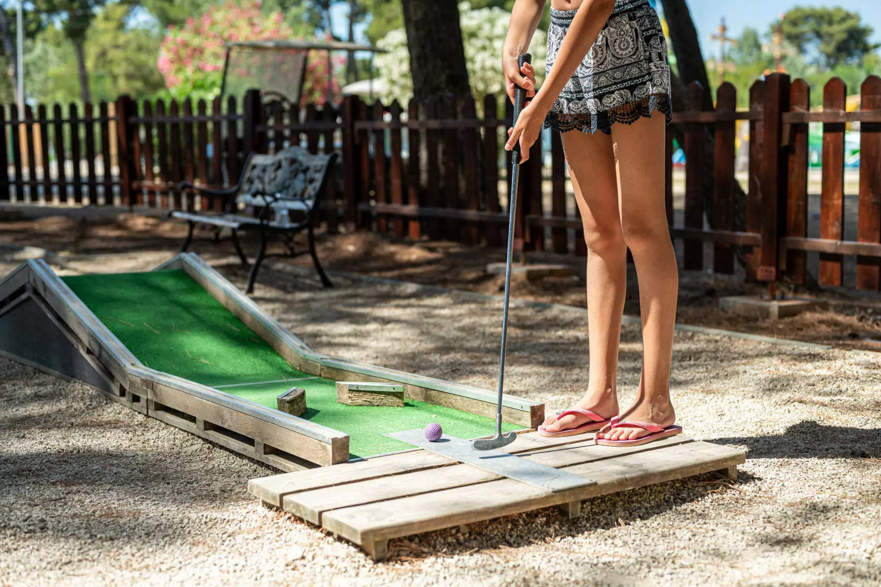 ragazza che gioca a minigolf in camping