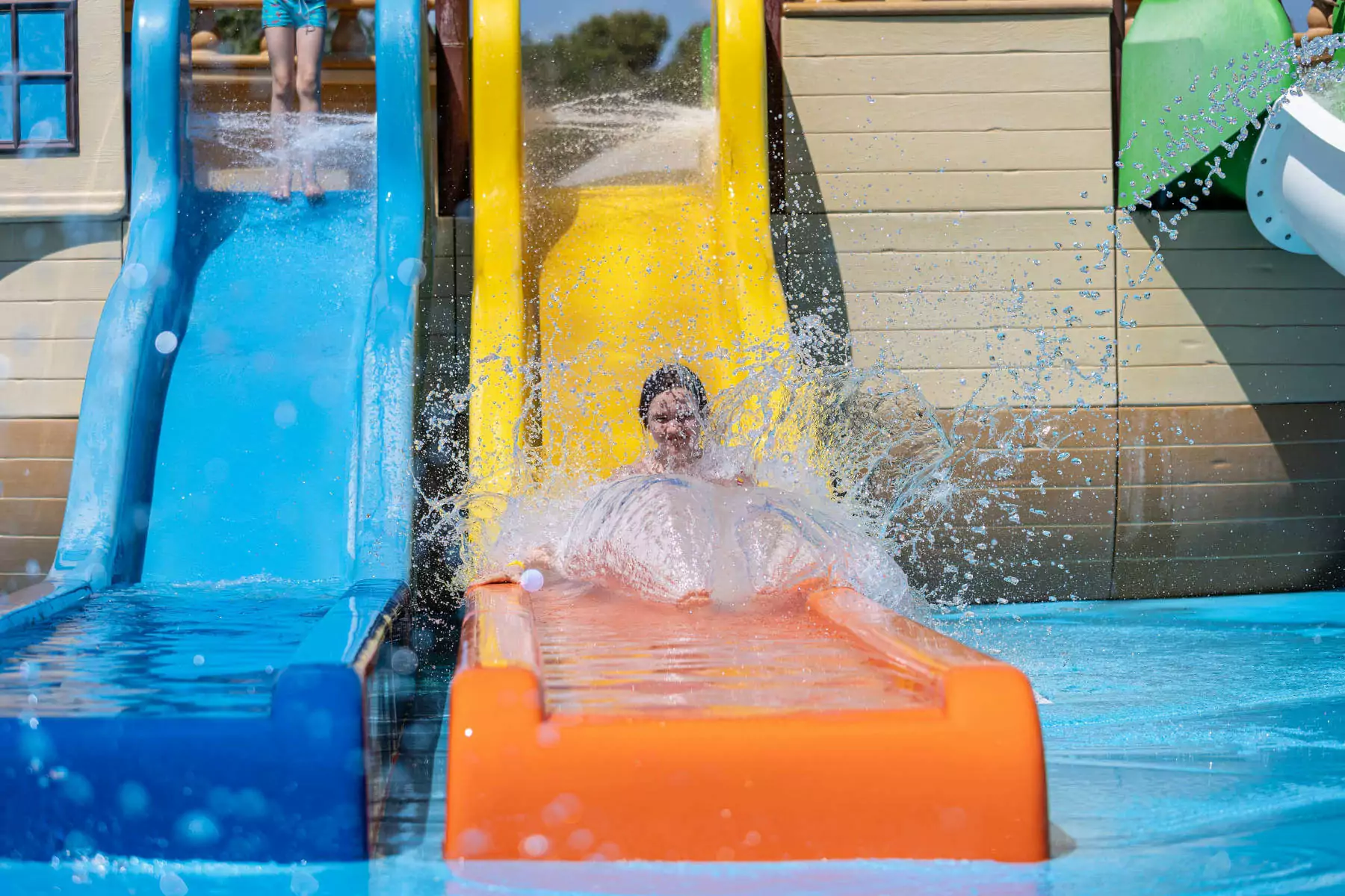 bambina che scende dallo scivolo della piscina al bivillage