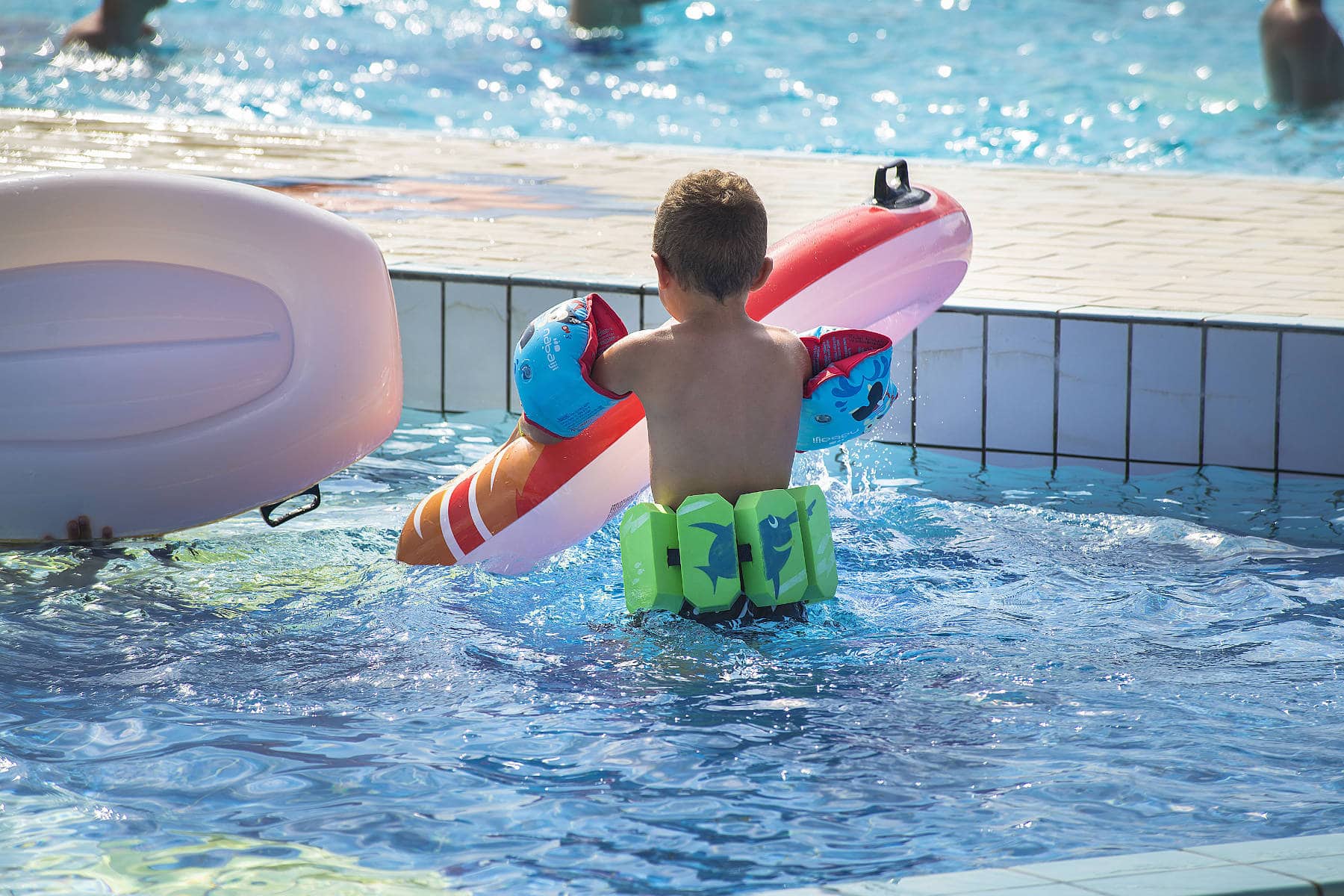 bambino con salvagente e braccioli nella piscina residence pool