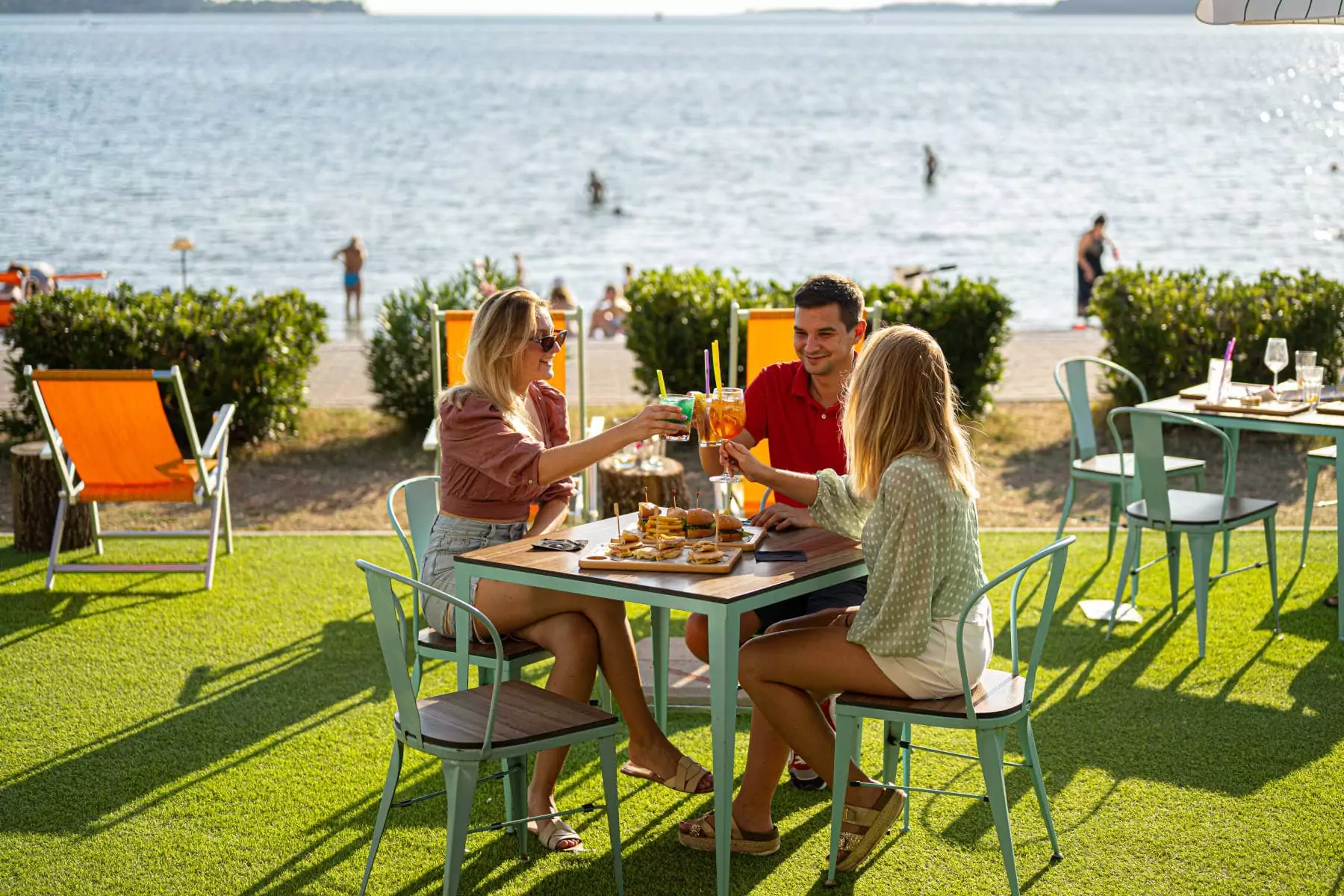 ragazzi che fanno aperitivo nel bar con giardino vicino al mare a Fazana