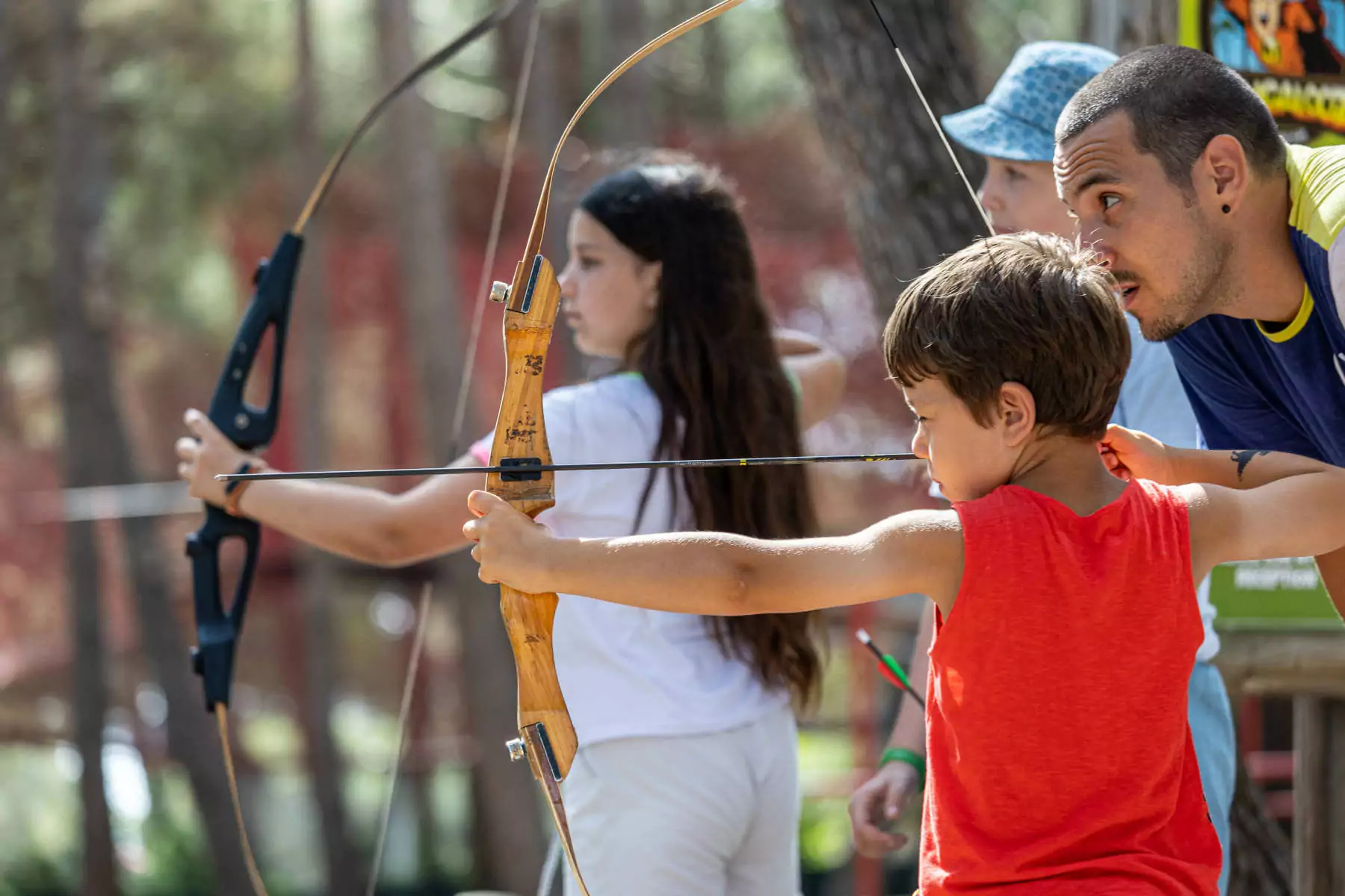 istruttore che insegna ai bambini come tirare con l'arco