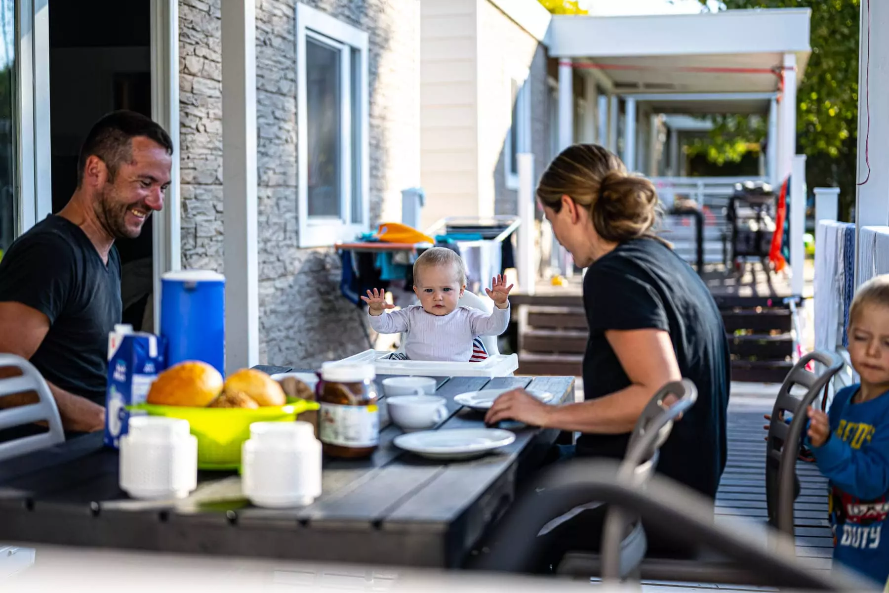 papà, mamma e due bambini in veranda che fanno colazione