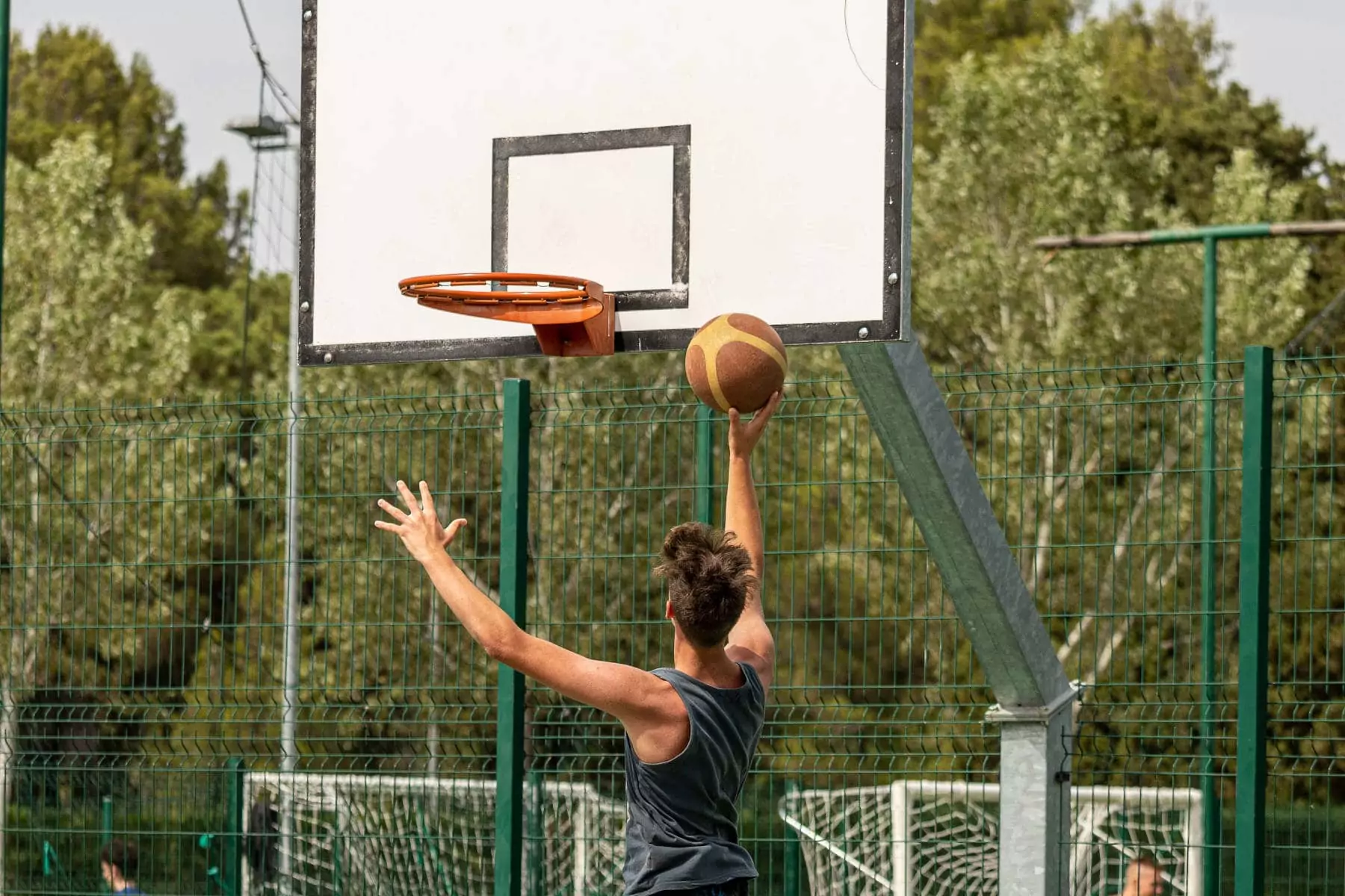 ragazzo che salta a canestro nel campo da basket