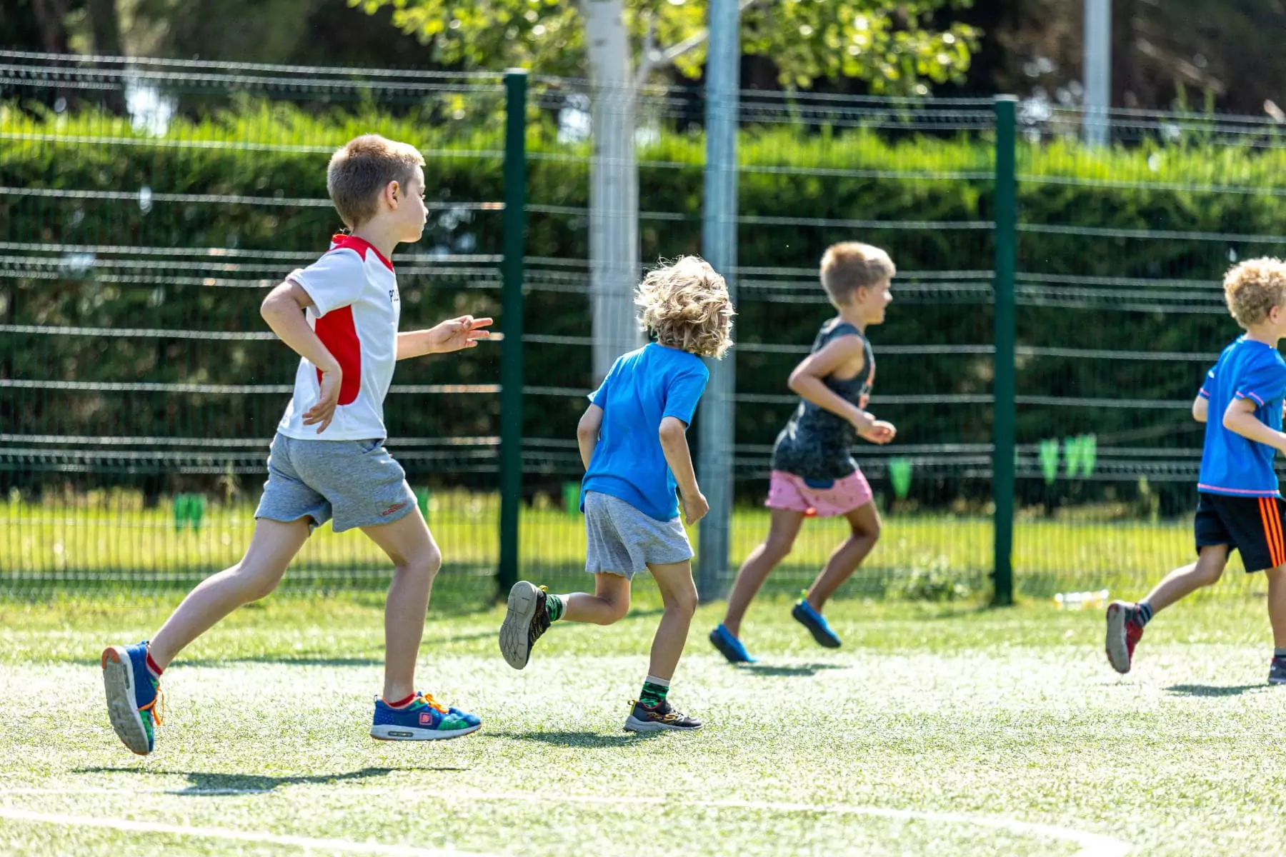 bambini si rincorrono mentre giocano a calcetto