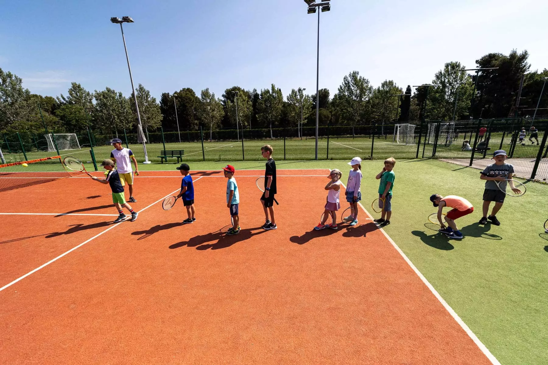 bambini in fila per giocare a tennis