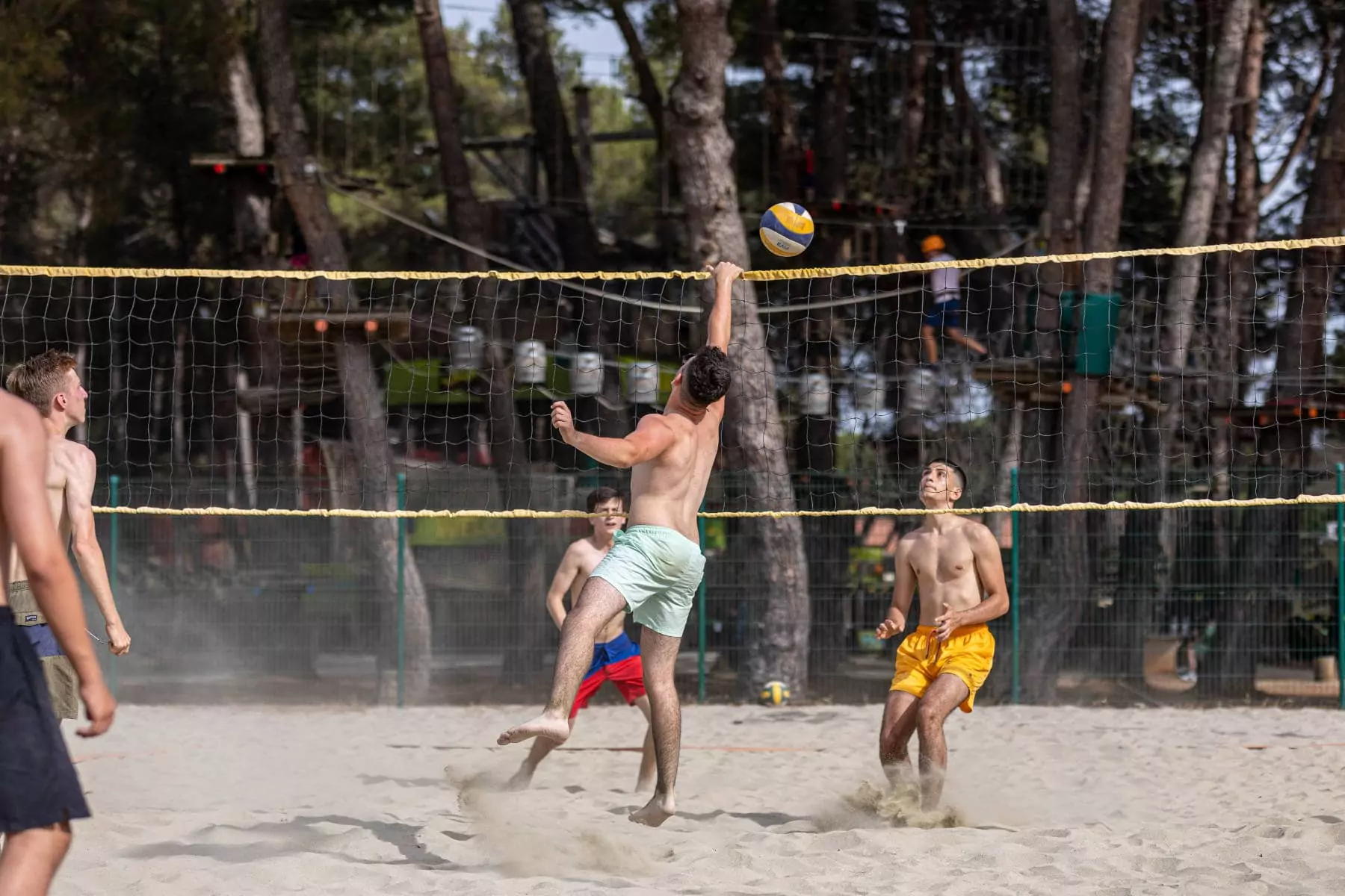 ragazzo che manda la palla oltre la rete del beach volley al BiVillage