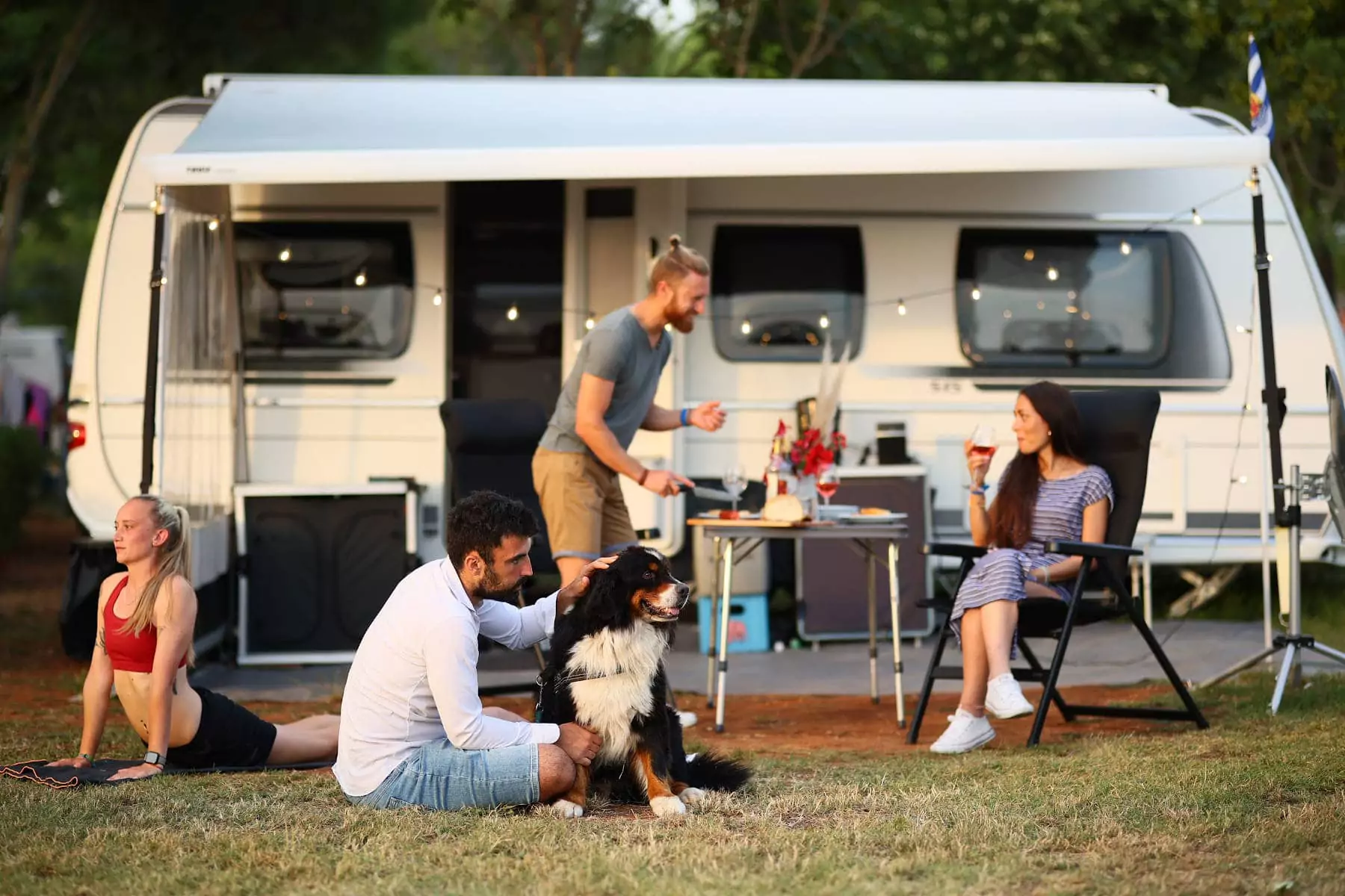 amici con cane davanti alla roulotte nel camping bivillage