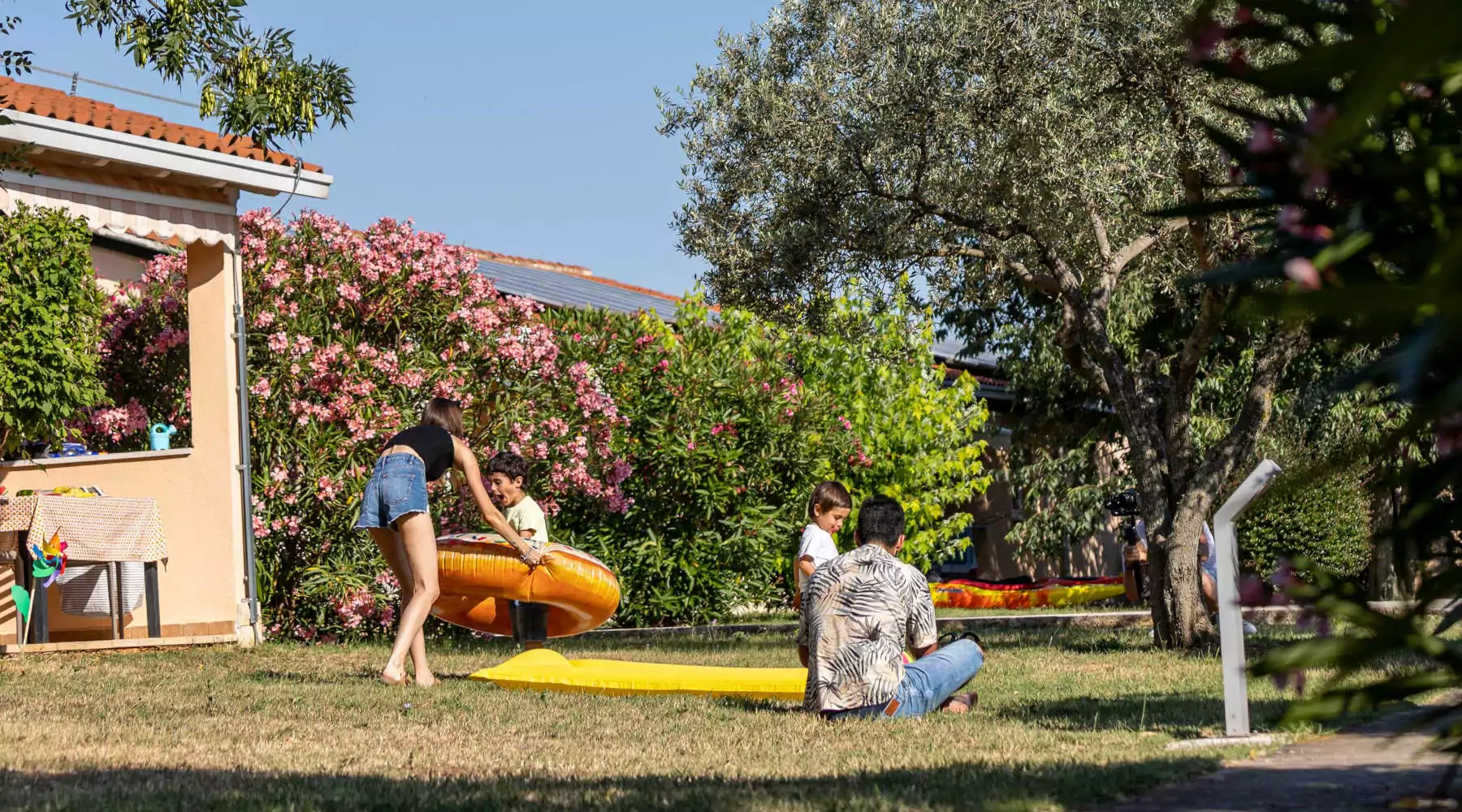 famiglia che gioca felice nel giardino dell'appartamento nel villaggio vacanze