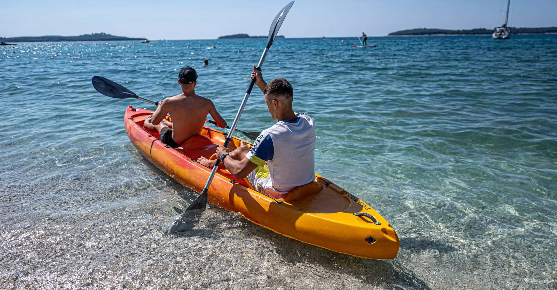 kayak bivillage croazia banner coppia di ragazzi su kayak in riva al mare adriatico in istria