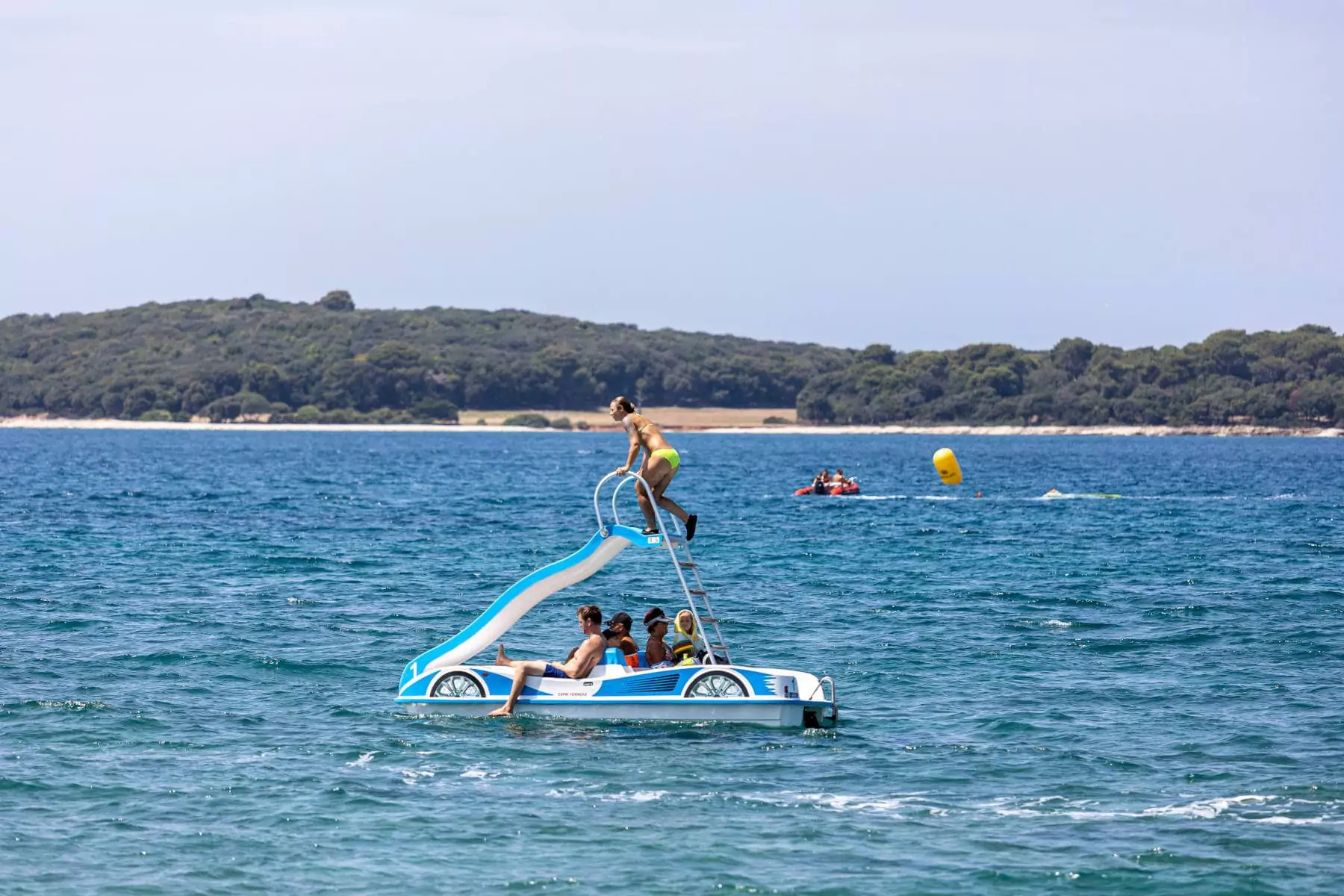 ragazzi in pedalò nel mare istriano con vista su penisola