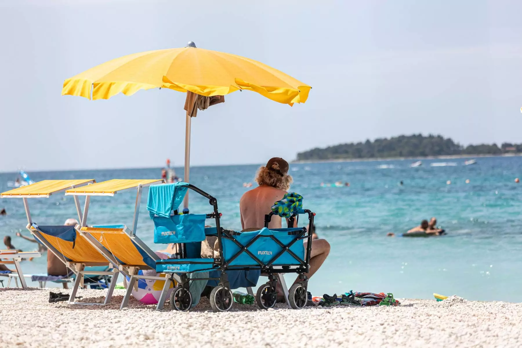 uomo seduto sotto l'ombrellone in riva al mare in Istria