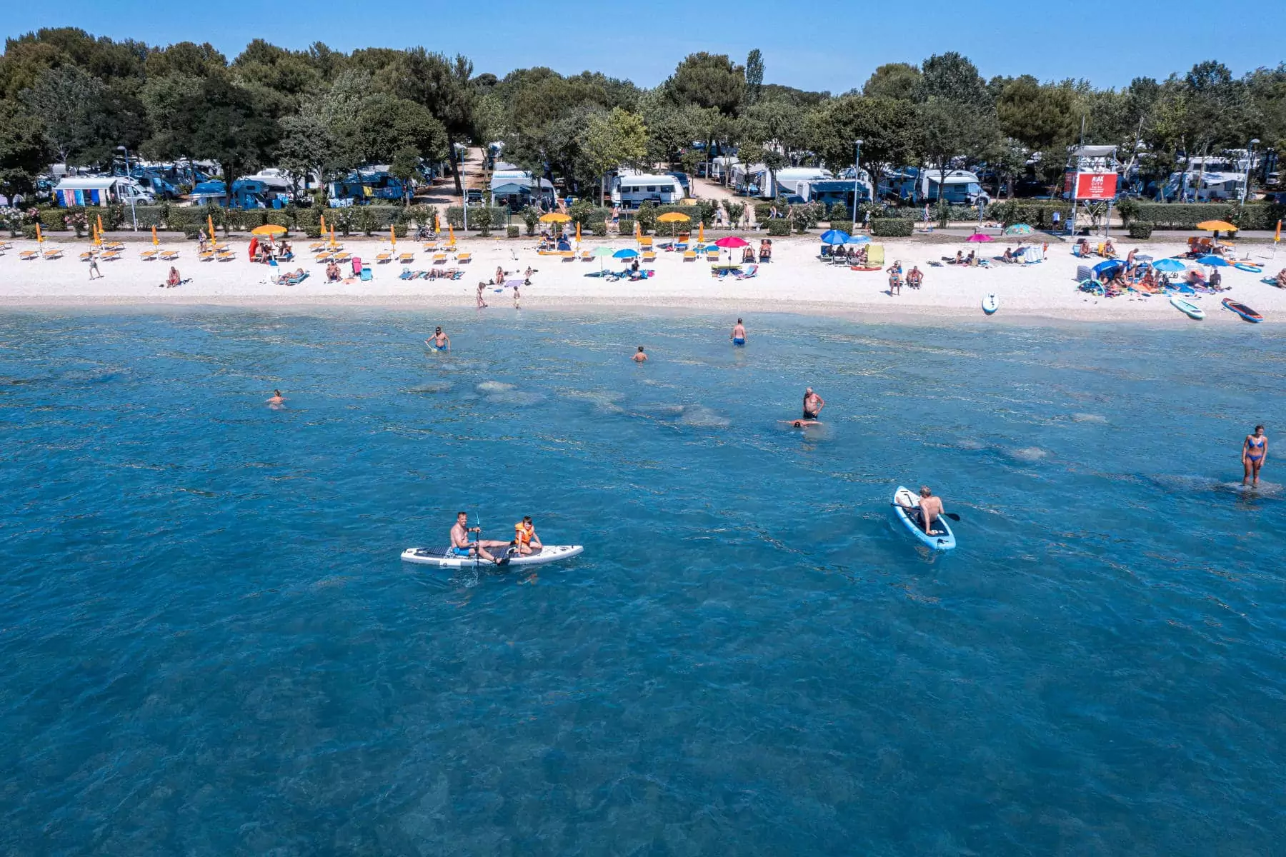 gente in mare con kayak e in spiaggia del bivillage