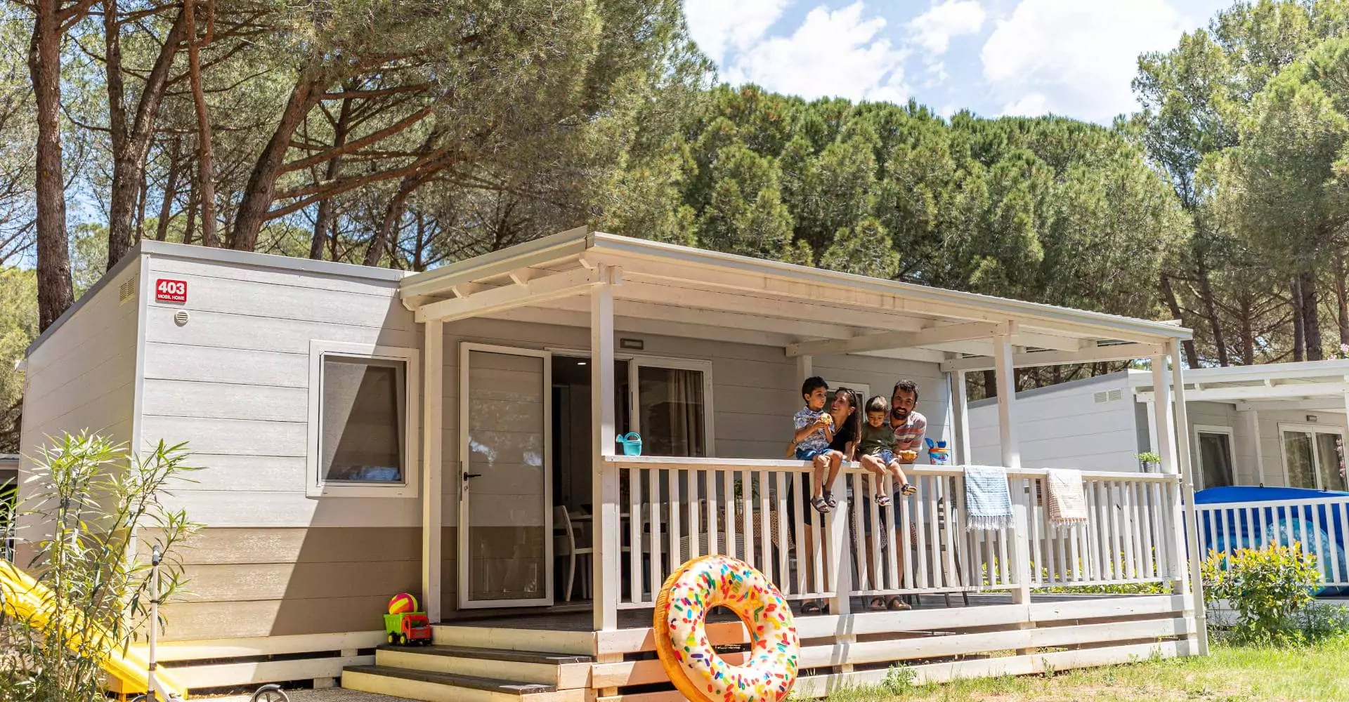 famiglia su veranda delle mobile home nel centro vacanze in