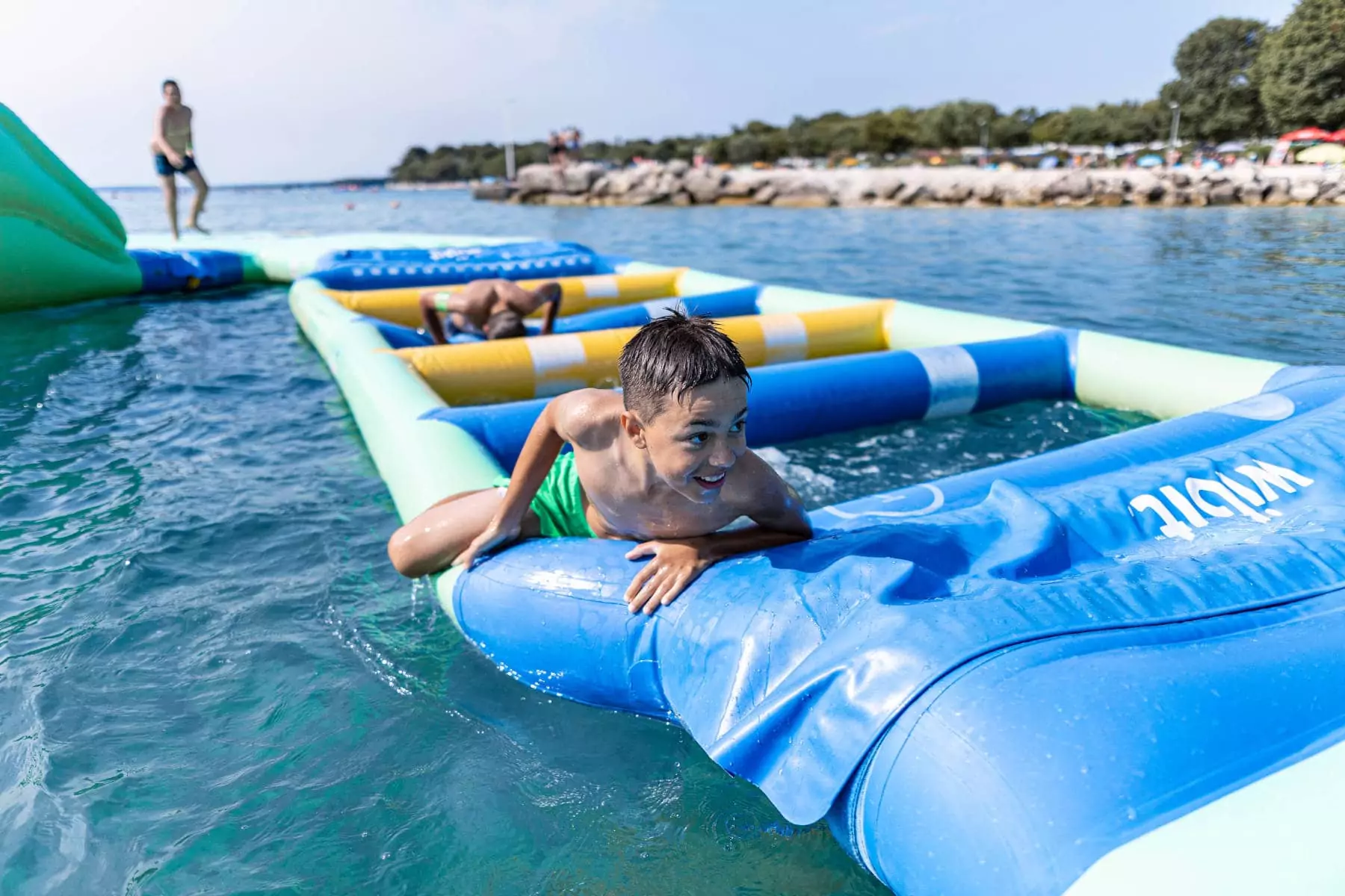 bambino che gioca su waterpark gonfiabile in mare in Istria