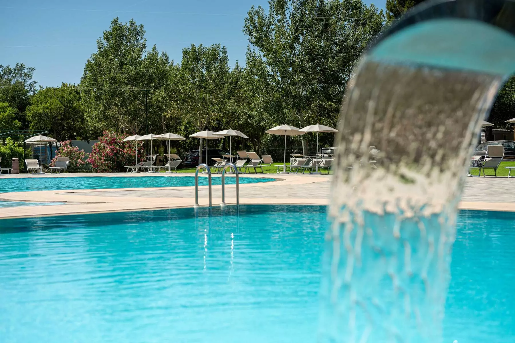 piscine con getti d'acqua e sdraio