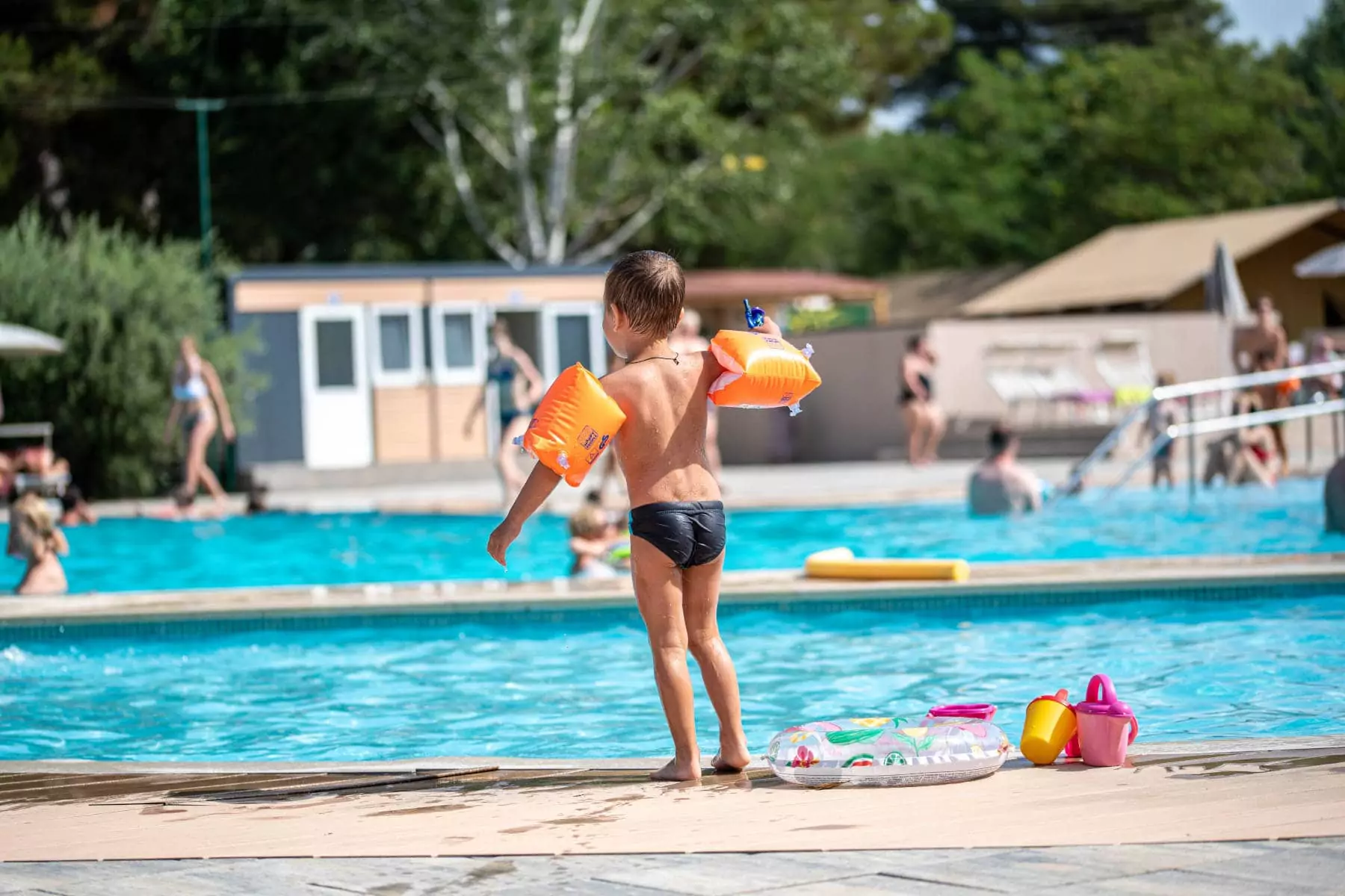 bambino con braccioli a bordo piscina