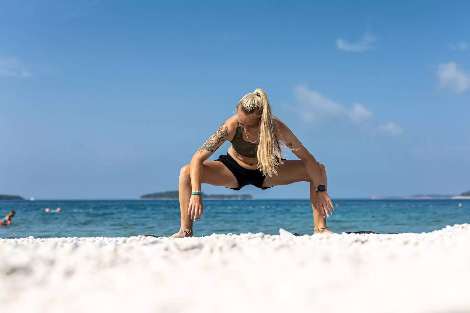 ragazza che fa stretching sulla spiaggia di sassi in croazia