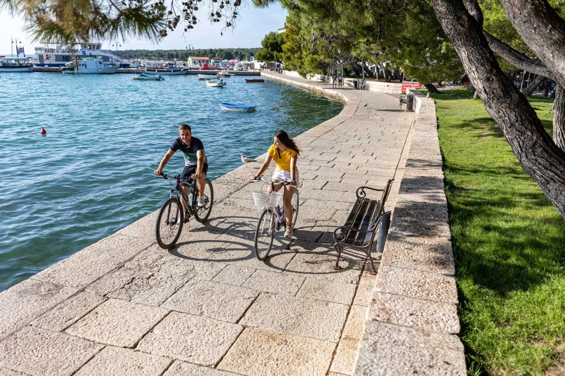 coppia che corre in bicicletta lungo il porto al centro vacanze bivillage