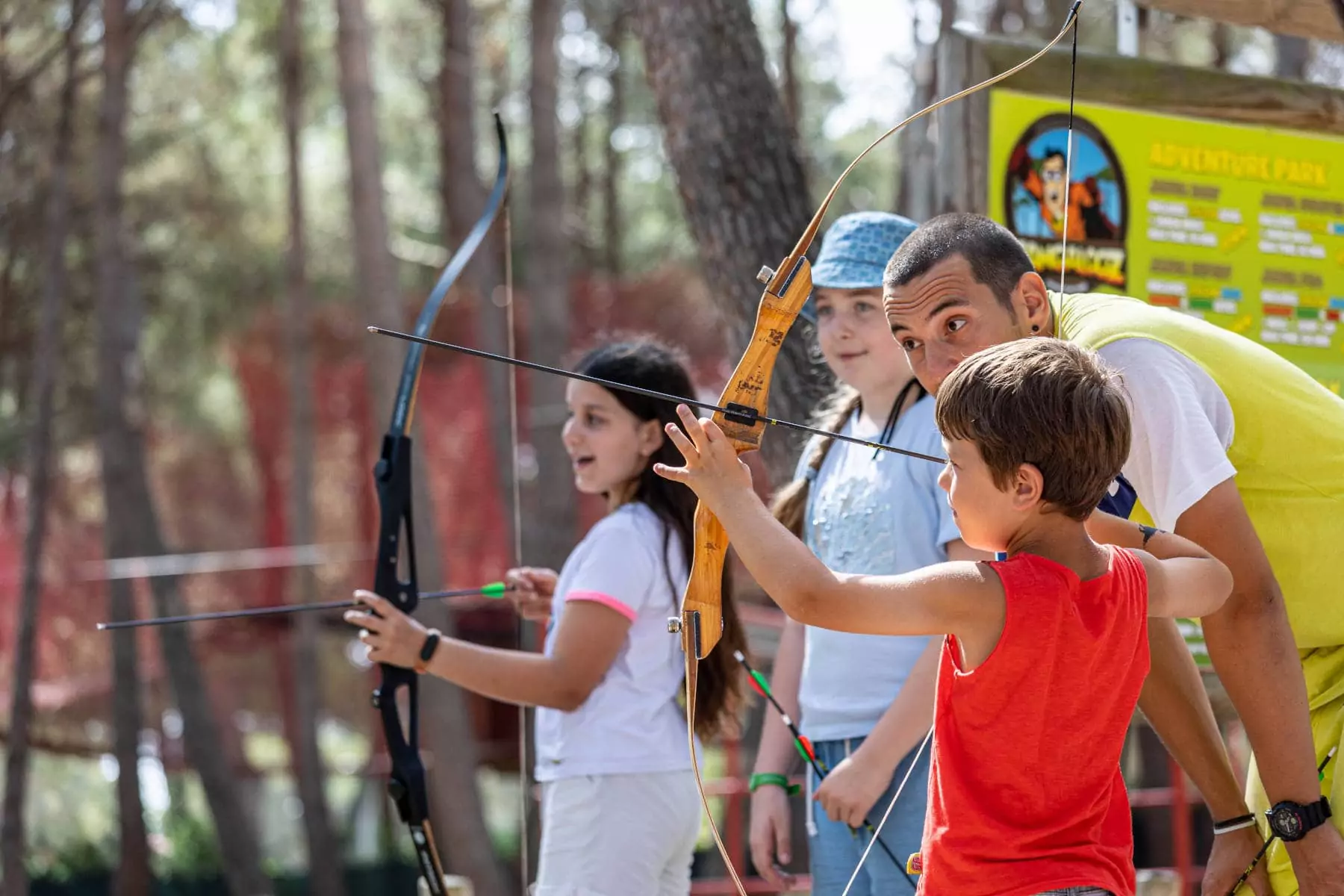 istruttore di tiro con l'arco che insegna ai bambini nel villaggio bivillage