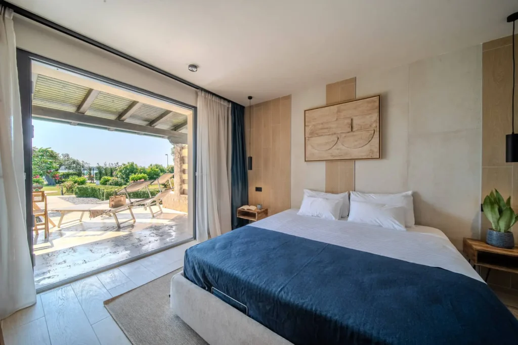 Camera da letto con vista giardino e patio esterno.